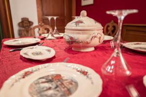 a table with plates and a tea pot on a red table cloth at S'Hüsli - Maison vigneronne au coeur du vignoble in Bergheim