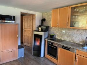 a kitchen with a stove with a fire in the oven at Ferienhaus Ramersdorf in Kollnburg