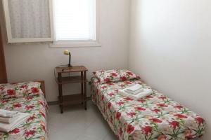 a room with two beds and a table with a window at Villa Valchiria in Campomarino