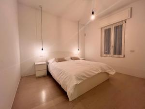 a white bedroom with a bed and a window at Casa Pina - Milan - Malpensa - Rho Fiera in Magenta