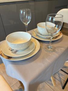 a table with plates and wine glasses on it at Studio Apartment in Ferndown