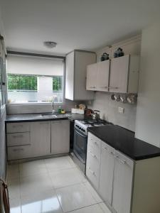 a kitchen with white cabinets and a black counter top at Luna de Valencia in Mar del Plata