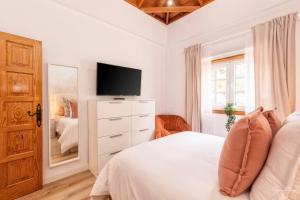 a bedroom with a bed and a tv on a dresser at Sweet Aroma, vistas únicas y tranquilidad in Breña Baja