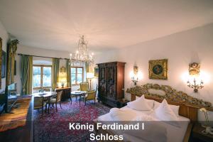 um quarto com uma cama, uma secretária e uma sala de jantar em Schloss Hotel Fernsteinsee em Nassereith