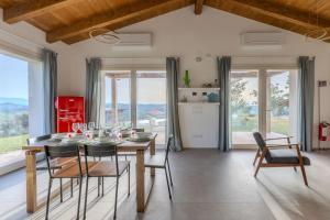 a dining room with a table and chairs and windows at Villa Margherita in Francavilla dʼEte