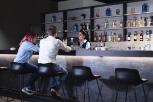 un homme et une femme assis dans un bar dans l'établissement Garner Hotel Augsburg Nord by IHG, à Augsbourg
