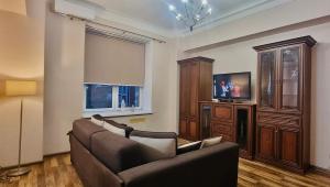 ein Wohnzimmer mit zwei Sofas und einem Fernseher in der Unterkunft Kyiv Khreschatyk 27 Apartment in Kiew