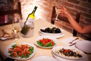 - une table avec des assiettes de nourriture et une bouteille de vin dans l'établissement Metropoli's, à Taurianova