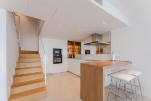 a kitchen with white walls and wooden countertops at SVB Aquasuites Luxury Penthouse - A02 in Santiago del Teide