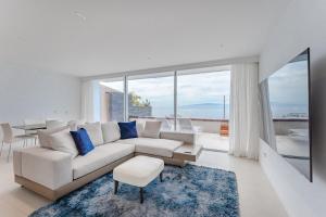 a living room with a white couch and blue pillows at SVB Aquasuites Luxury Penthouse - A02 in Santiago del Teide