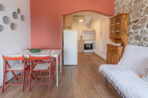 a kitchen with a table and chairs and a white refrigerator at Anna's Horizon in Samothraki