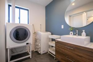 a bathroom with a sink and a large mirror at Villa Olive Myoko in Myoko