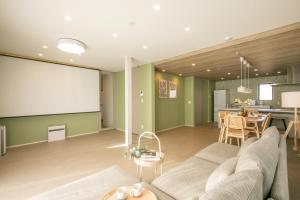 a living room with a couch and a large whiteboard at Villa Olive Myoko in Myoko +50 photos