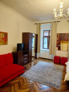 a living room with a red couch and a tv at Casa Sforii Brasov in Braşov