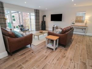 Una sala de estar con dos sofás y un televisor. en Breamish, en Alnwick