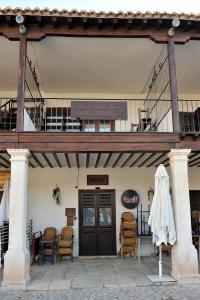 un bâtiment avec un balcon, une table et des chaises dans l'établissement Alojamiento Colmenar de Oreja Plaza Mayor, à Colmenar de Oreja
