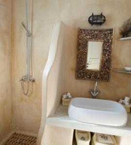 bagno con lavandino e specchio a parete di Waterfront Luxurious Villa - Kea Island a Melissaki