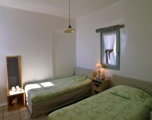 una camera da letto con due letti e uno specchio di Waterfront Luxurious Villa - Kea Island a Melissaki Altre 32 foto
