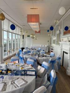 a banquet hall with white tables and blue chairs at The Palace Hotel in Southend-on-Sea +39 photos