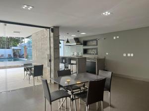 a dining room and kitchen with a table and chairs at Ziza Hospedagem in Maringá