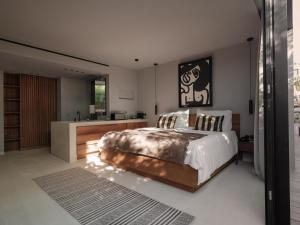 a bedroom with a large bed and a kitchen at OKU Ibiza in San Antonio
