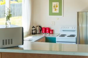 a kitchen with a white stove and a refrigerator at Lakeview Cottage - Rainbow Point Holiday Home in Taupo +11 photos