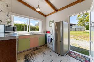 a kitchen with a stainless steel refrigerator at Lakeview Cottage - Rainbow Point Holiday Home in Taupo