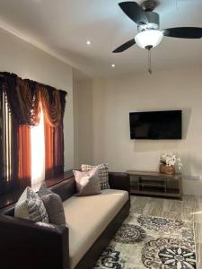 a living room with a couch and a ceiling fan at Phoenix Apartments in Calliste Land Settlement