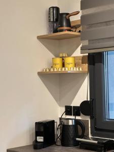 a kitchen with shelves with pots and pans on the wall at La Petite Mansion, next to the city center! in Volos