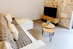 a living room with a couch and a tv at Aretha Mansion - Chora Samothrace in Samothraki