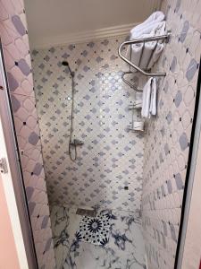 a bathroom with a shower with blue and white tiles at Riad 052 in Marrakesh +28 photos