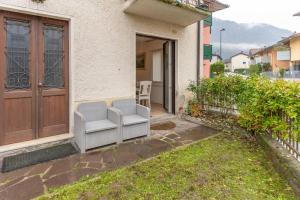 a pair of chairs sitting on the porch of a house at La Vecchia Sartoria, Caldonazzo Ospitar in Caldonazzo