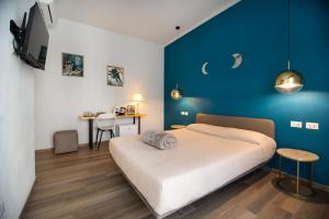 斯培西亚Bianca Elegance Rooms的一间带床和蓝色墙壁的卧室