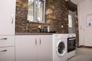 a kitchen with a washer and a stone wall at Caviro-traditional Stone House In Chora in Samothraki