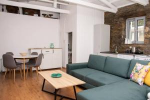a living room with a green couch and a table at Caviro-traditional Stone House In Chora in Samothraki