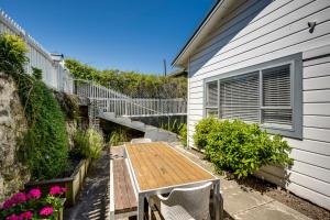 a patio with a wooden table next to a building at Views on Colenso - Napier Holiday Home in Napier