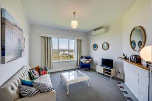 a living room with a couch and a table at Views on Colenso - Napier Holiday Home in Napier