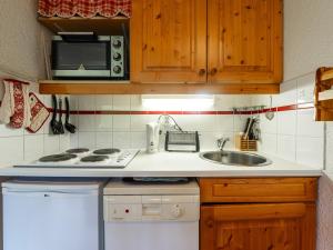 Una pequeña cocina con fregadero y microondas. en Les Eterlous - 8 - Appt Montagne 4-6 pers, en Morillon