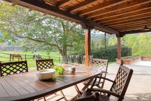 a wooden table and chairs on a patio at The Stone House in Bárcena de Pie de Concha