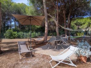 a patio with a table and chairs and an umbrella at Riccio di Mare in Lacona