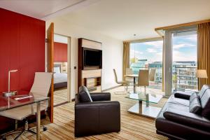ein Wohnzimmer mit einer Couch und einem Tisch in der Unterkunft Courtyard by Marriott Duesseldorf Hafen in Düsseldorf
