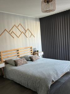sypialnia z dużym łóżkiem i żyrandolem w obiekcie Grand T2 renové, plein centre, 62 m² w mieście Villard-de-Lans