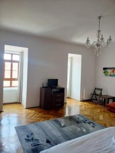 a living room with a bed and a chandelier at Casa Sforii Brasov in Braşov