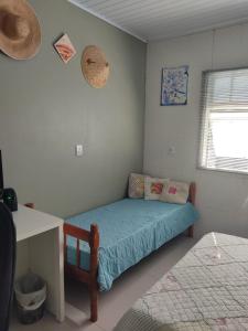 a small bedroom with a bed and a window at Casa verão 2025 in Tramandaí