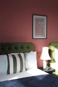 a bedroom with a bed with a red wall at Stylish Digbeth Apartment, Sleeps 12 Opposite Birmingham Coach Station, perfect for large groups contractors in Birmingham