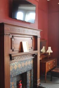 a living room with a fireplace with a television above it at Stylish Digbeth Apartment, Sleeps 12 Opposite Birmingham Coach Station, perfect for large groups contractors in Birmingham