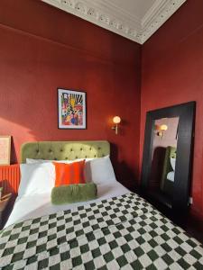 a bedroom with red walls and a bed with orange pillows at Stylish Digbeth Apartment, Sleeps 12 Opposite Birmingham Coach Station, perfect for large groups contractors in Birmingham +66 photos