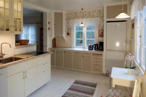 a kitchen with white cabinets and a sink at Fäbron house in Timbonäs