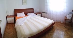 een slaapkamer met een groot bed en een raam bij Holiday Home Nona in Drage