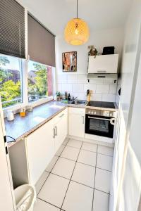 a kitchen with white cabinets and a stove top oven at Uhlpartment - im Herzen von Munster in Munster im Heidekreis +18 photos